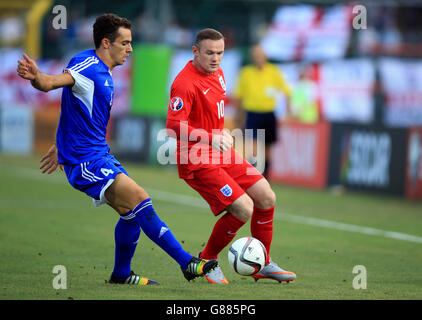 England's Wayne Rooney (right) and San Marino's Cristian Brolli battle for the ball during the UEFA European Championship Qualifying match at the Stadio Olimpico di Serravalle. Stock Photo