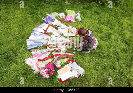 A young boy lays flowers at the spot where Mary-Ann Leneghan's body was found in Prospect Park on Saturday morning. Officers investigating the 16-year-old's murder arrested a man in his 20s in London today, Thames Valley Police said. Stock Photo