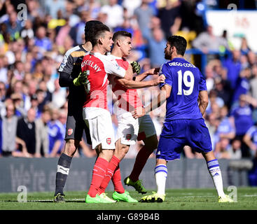 Arsenal's Gabriel Paulista (centre) and Chelsea's Diego Costa exchange words during the Barclays Premier League match at Stamford Bridge, London. Stock Photo