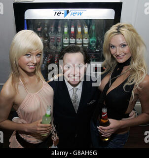 Young Scottish entrepreneur Michael Bowes with models Amy McLelland (left) and Leanne McGill (right) in front of new robotic bartender, Barhand. 23-year-old Bowes claims the vending machine will revolutionise the bar and clubbing industry in Europe. Stock Photo