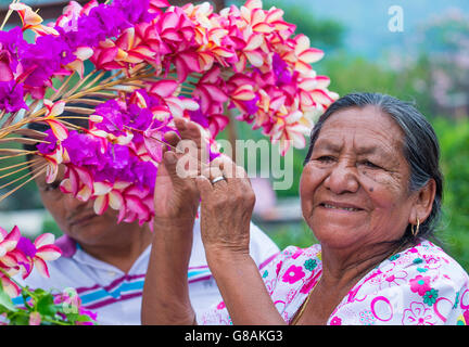 A Salvadoran woman decorates palm fronds with flowers during the Flower & Palm Festival in Panchimalco, El Salvador Stock Photo