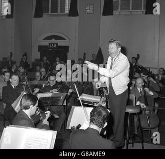 Danny Kaye conducts a rehearsal of the London Philharmonic Orchestra at Battersea Town Hall in London. He will conduct the orchestra at the LPO appeal fund concert at the Royal Albert Hall tomorrow evening. Stock Photo
