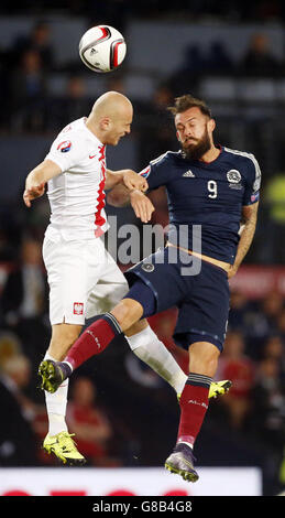 Poland's Michal Pazdan and Scotland's Steven Fletcher (right) battle for the ball during the UEFA European Championship Qualifying match at Hampden Park, Glasgow. Stock Photo