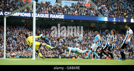 Manchester City's Sergio Aguero (centre) scores his side's first goal of the game during the Barclays Premier League match at the Etihad Stadium, Manchester. Stock Photo