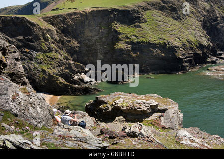 UK, Wales, Ceredigion, Llangrannog, senior couple amongst rocks in sheltered cove on coast path Stock Photo