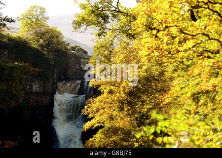 Two people take pictures of the autumn scenery at High Force Waterfall in Teesdale, County Durham. Stock Photo