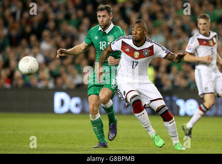 Germany's Jerome Boateng and Republic of Ireland's Daryl Murphy (left) battle for the ball during the UEFA European Championship Qualifying match at the Aviva Stadium, Dublin. Stock Photo
