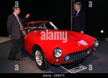 (L to R) Charles Denton, godson and executor to the estate of the late Richard Colton with RNLI Chief Executive Paul Boissier, stand next to a 1960 Ferrari 250 GT short-wheelbase (SWB) Berlinetta chassis 1995 GT, of which just 167 were made with a mere ten being supplied new to the UK market, one of the star lots with no reserve, on display prior to the H&H Classics, classic cars and motorcycles sale, at the Imperial War Museum, Duxford, one of two of the rarest and most sought-after Ferraris ever made which are being sold to raise funds for the Royal National Lifeboat Institution (RNLI). Stock Photo