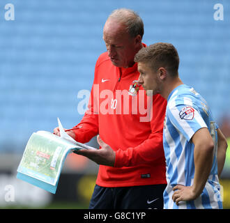 Soccer - Sky Bet League One - Coventry City v Blackpool - Ricoh Arena. Coventry City goalkeeper coach Steve Ogrizovic gives instructions to Coventry City's Aaron Phillips (right) Stock Photo