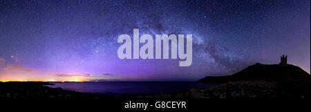 Lilburn Tower/Dunstanburgh Castle with the Milky Way and Northern Lights Stock Photo