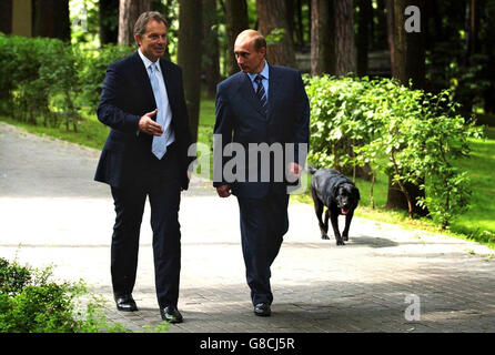 Britain's Prime Minister Tony Blair (left) walks with Russian President Vladimir Putin and his dog Konie at his private dacha outside Moscow. Mr Blair conceded today that he was taking over the presidency of the EU at 'an interesting time' for Europe as he joined Mr Putin at the start of a hectic diplomatic week that ends with a crunch EU summit in Brussels. Stock Photo