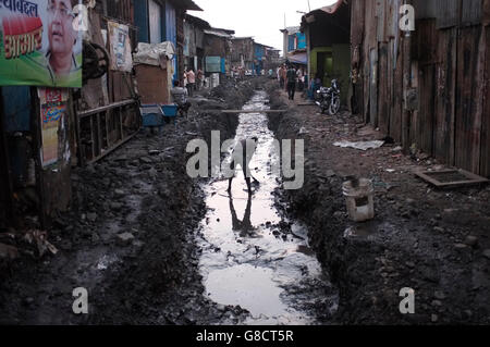 a man working in the drainage ditch in a slum street in kurla west, Mumbai, India Stock Photo