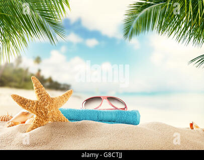 Summer accessories on sandy beach, blur sea on background. Summer exotic relaxation concept Stock Photo