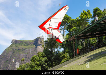 RIO DE JANEIRO - MARCH 22, 2016: A hang gliding instructor takes off with a passenger from Pedra Bonita, in the Tijuca Forest. Stock Photo
