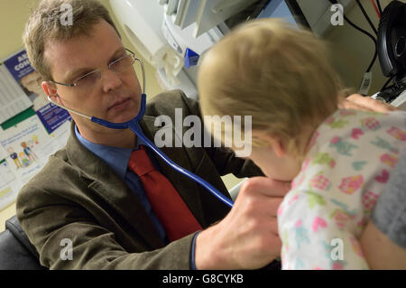 A doctor examining the health of a toddler using a stethoscope. England. UK Stock Photo