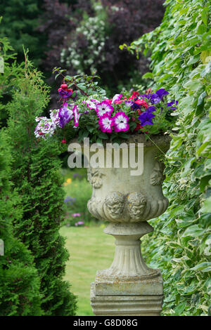 Stone planters with flowers in garden Stock Photo - Alamy