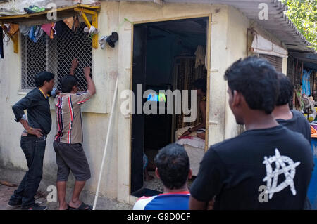 men crowd around a house to watch the television inside showing india versus pakistan in the world cup cricket, Mumbai, India Stock Photo