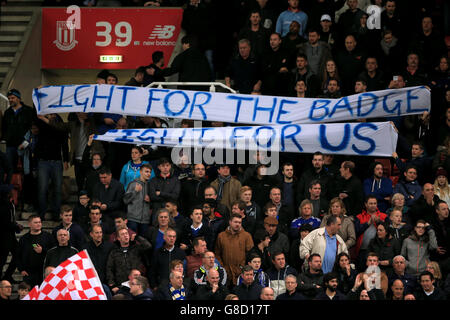 Chelsea fans in the stands hold up banners reading 'Fight For The Badge, Fight For Us' during the Barclays Premier League match at the Britannia Stadium, Stoke-on-Trent. Stock Photo