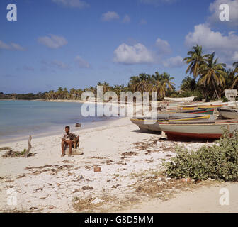 14 year old Warrigan Beltane and his dog Toby on an otherwise deserted beach in Anguilla. British troops, as well as British Policeman, were sent to island following political unrest. The Island was bidding for independence from Great Britain. Stock Photo