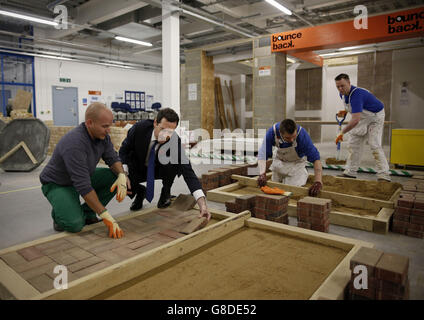 British Chancellor of the Exchequer George Osborne (second left) lays a brick in block-paving demonstration during a tour of HM Prison Brixton in south London. Stock Photo