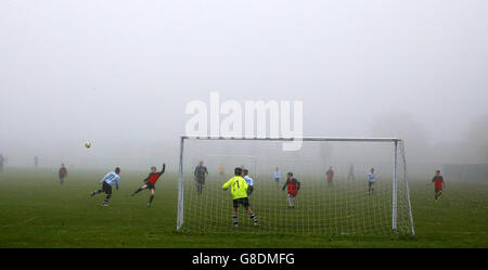 Children play a Sunday League football match during low fog in Netherley, Liverpool. Stock Photo
