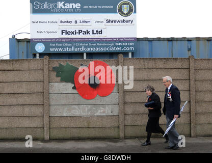 A poppy on display next to the match sign outside the stadium before the Emirates FA Cup, First Round match at the Gainsborough Martin & Co. Arena, Gainsborough. Stock Photo