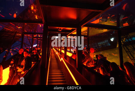 Essen, Germany. 25th June, 2016. Visitors stand on a moving walkway on their way to the Ruhr Museum on the premises of the former 'Zollverein' colliery in Essen, Germany, 25 June 2016. Interessted visitors can enjoy concerts, shows and theatre performances, situated on stages between decommissioned furnaces, gas tanks and coal mines, during the 'Nacht der Industriekultur' (lit. night of industrial culture). Photo: Bernd Thissen/dpa/Alamy Live News Stock Photo