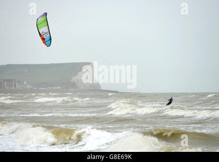 Seaford, UK. 29th June 2016. Kite surfers take advantage of the wet and windy summer weather in Seaford Bay, East Sussex. Credit: Peter Cripps/Alamy Live News Stock Photo
