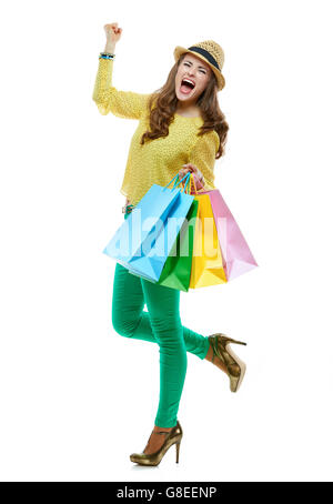 Colourful shopping vibes. Full length portrait of happy brunette woman in hat and bright clothes with colorful shopping bags rejoicing on white background Stock Photo