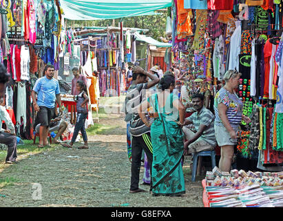 Shops and customers at the Wednesday flea market selling varieties of merchandise at Anjuna Beach in Goa, India. Stock Photo