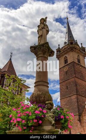 Sainte-Odile fountain and Kappelturm in Obernai village by day, Alsace, France Stock Photo