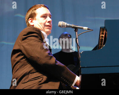 Jools Holland performing at the piano on stage with his ...