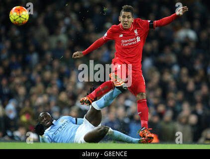 Liverpool's Roberto Firmino skips out of a tackle by Manchester City's Eliaquim Mangala during the Barclays Premier League match at the Etihad Stadium, Manchester. Stock Photo