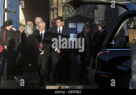 Labour leader Jeremy Corbyn (centre left) and his predecessor Ed Miliband (centre right) talk to mourners after attending the funeral of former Labour MP Michael Meacher at St Mary's Church in Wimbledon, London. Stock Photo