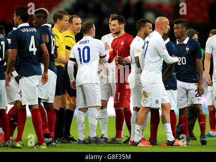 England captain Wayne Rooney (left) and France captain Hugo Lloris shake hands after the international friendly match at Wembley Stadium, London. Stock Photo