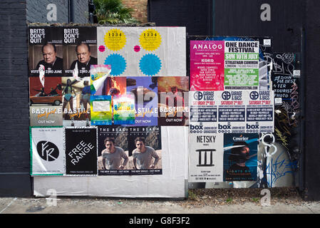 Posters on a wall in Chance Street , Shoreditch, East London, UK. Stock Photo
