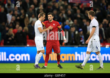 England v France - International Friendly - Wembley Stadium. France goalkeeper Hugo Lloris and England's Harry Kane (left) embrace as Tottenham Hotspur teammate Eric Dier (right) looks on Stock Photo