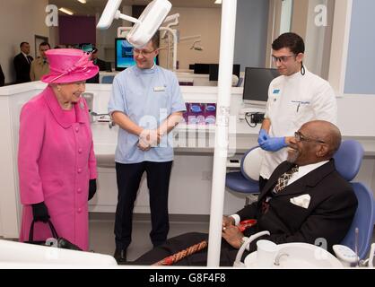 Queen Elizabeth II meets patient Gerald Brown in a dental chair used to train dentists during a tour of the the new Birmingham Hospital and School of Dentistry. Stock Photo