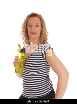 A blond woman standing in profile with her water bottle in her hand, isolated for white background. Stock Photo