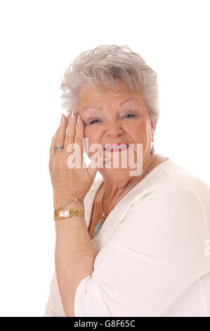 A beautiful senior woman with gray hair holding her hand on her face isolated for white background. Stock Photo