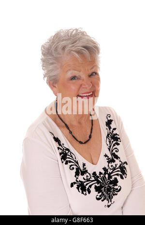 A lovely senior woman in her seventies in a portrait image smiling looking in camera, isolated for white background. Stock Photo