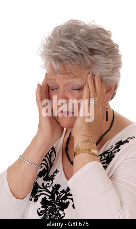 A lovely seventy senior woman holding her hands on her head for severe headache, isolated for white background. Stock Photo