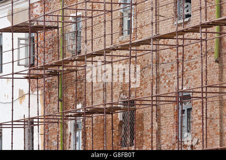 Scaffolding covering old brick building under restoration Stock Photo