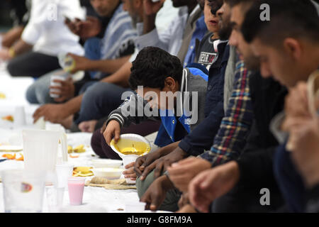 Muslim men break their fast after sunset during the holy month of Ramadan at Birmingham Central Mosque Stock Photo