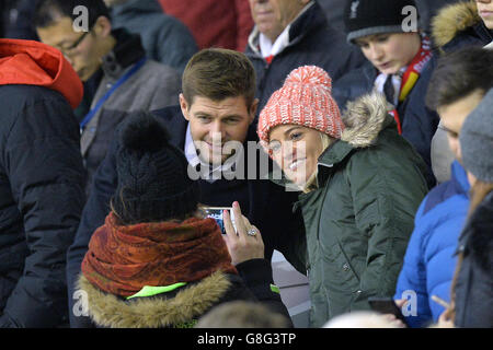 Former Liverpool player Steven Gerrard poses with a supporter for a photograph in the crowd during the Barclays Premier League match at Anfield, Liverpool. Stock Photo