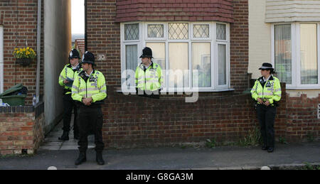 Anti-terror police stand outside a house in Northern Road, which they raided in connection with the London 'burning cross' bombing gang. Officers - some of whom were armed - swooped on the bay-fronted, 1930s semi-detached at about 7pm on Wednesday night. No arrests were made and no explosive substances are believed to have been recovered. It is thought the house may be connected to one of the cars recovered at Luton railway station. Stock Photo