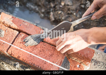 plasterer making up a brick wall with cement Stock Photo
