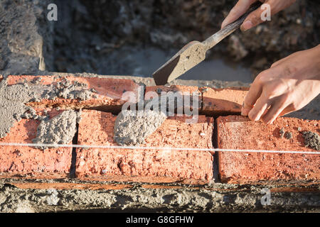 plasterer making up a brick wall with cement Stock Photo