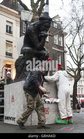 AK 47 (left) returns Banksy's sculpture 'The Drinker' as 'The Stinker' to Shaftesbury Avenue in London 'with some notable amendments' a decade after being removed. Stock Photo