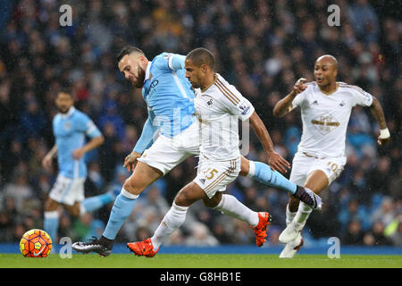 Manchester City's Nicolas Otamendi (left) and Swansea City's Wayne Routledge (right) battle for the ball during the Barclays Premier League match at the Etihad Stadium, Manchester. Stock Photo